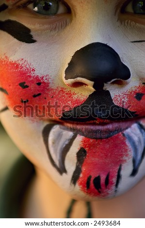 boy at a fete with face paint to look like a devil or demon