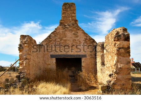 old ruins of a stone farmhouse full of weeds and rubble