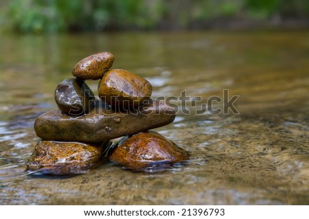 great image of tower of balancing rocks or stones in the river