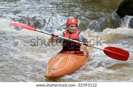 image of a teenage girl doing whitewater kayaking down a river