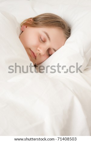 young woman asleep in bed under covers