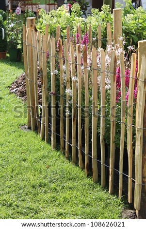 fence of wooden peg on the diagonal with flowers