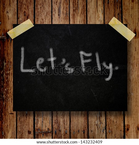 Let\'s fly on message note with wooden background