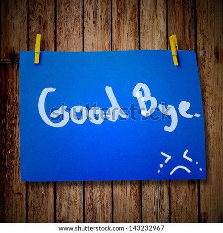 Good bye note paper and clothes peg on a wooden background with smile face