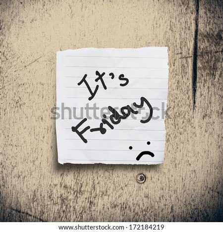 It\'s Friday on torn paper with wooden background