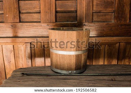 Old and dirty wooden ice bucket with wall, still life.
