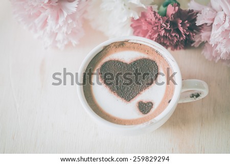Love message on coffee cup on wooden background with vintage colour effect. Still life.
