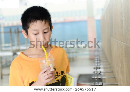 Asian boy drinking water in school.