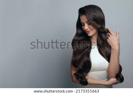 Image, Stock Photo Gorgeous dark-haired young woman stands with big eyes and demanding look in an old willow tree with fine shoulders