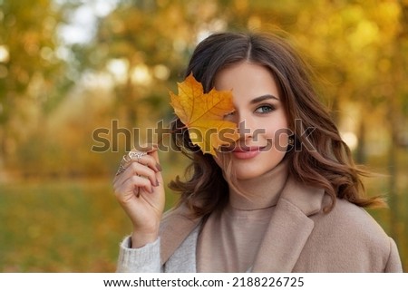 Similar – Image, Stock Photo Beautiful woman in autumn park wearing a burgundy beret, holding a red maple leaf. Young woman with long hair in stylish fall outfit, smiling and looking to the camera.