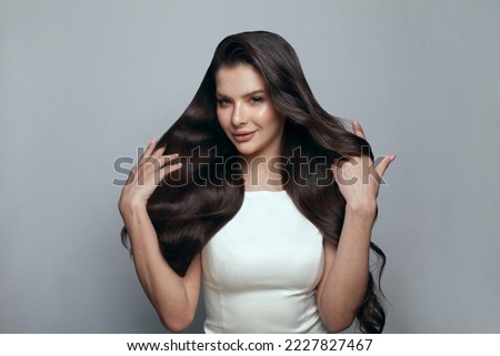 Similar – Image, Stock Photo Gorgeous dark-haired young woman stands with big eyes and demanding look in an old willow tree with fine shoulders