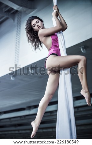 Young woman gymnast. On urban background.