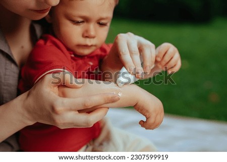 Mother puts cream on baby's hand in summer Foto stock © 