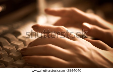 Woman hand on keyboard. Specialy made with soft focus and red tint.