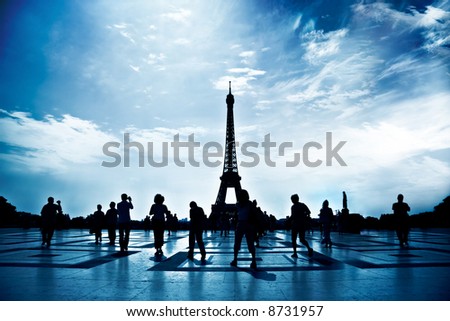 Walking people silhouettes in Paris. High contrast, blue tint and deep shadows.