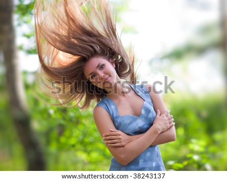 Young woman with fluttering hair outdoors positive portrait.