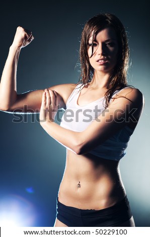 Young strong sexy woman showing her muscles.