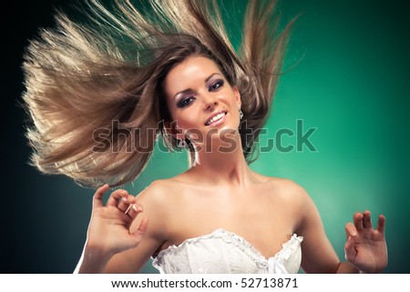 Woman with fluttering hair. On dark green background.