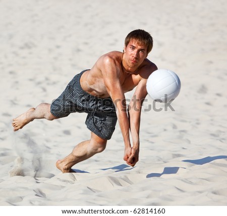 Young man catching ball in volleyball game.