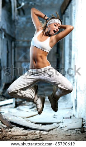 Young woman jumping on industrial background.