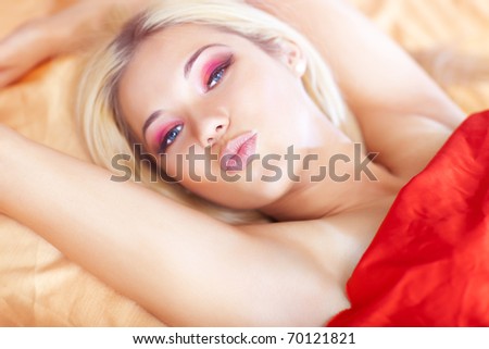 Young woman in bed showing kiss sign. Focus on lips.