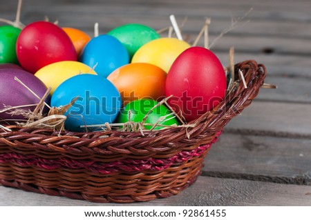 Easter eggs in  brown pannier on a wooden floor