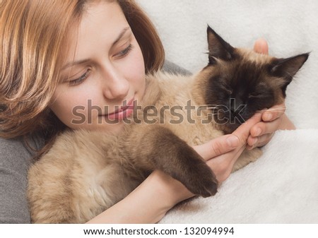 beautiful girl gently hugs kitten