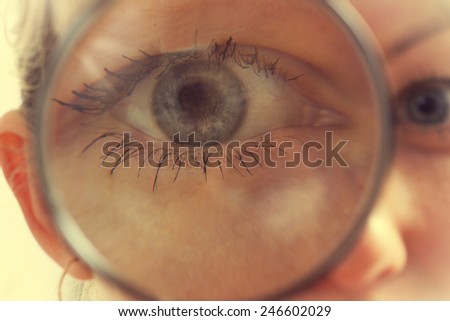 Funny woman looking through a magnifying glass