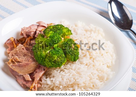 turkey meat topped with steamed broccoli and gravy on a side