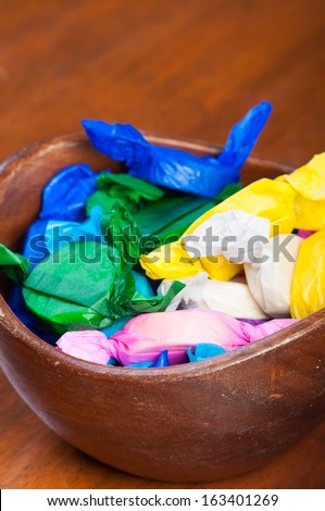colorful wrapped polvoron/milk candies on a wooden bowl