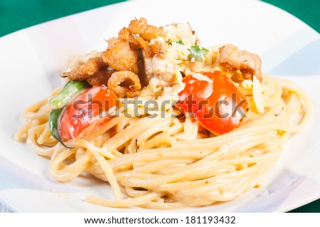 creamy pasta with chicken, tomatoes, and french beans topped with crispy chicken skin