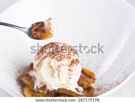 pan fried banana topped with vanilla ice cream and cocoa powder