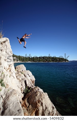 Leaping Into The Unknown A young man jumps from a cliff into the sea!