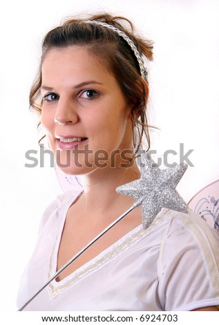 Young Christmas Fairy A young beautiful cute and happy Christmas fairy with wings and a magic wand getting ready for Christmas! Isolated over white!
