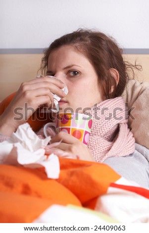 Young sick woman lying in bed. She is staying home from work.