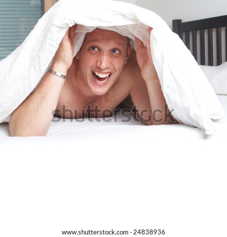 Young Man In His Bed Under The Sheets. Lots Of Copyspace. Stock Photo ...