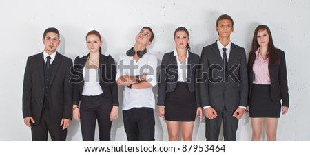 Young group of teenage business people with one young man standing out of the crowd.