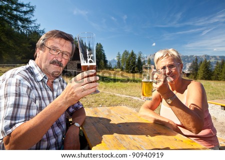 Happy retired couple drinking beer after a long hike