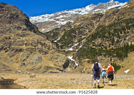 Family with senior parents and a young daughter hiking in the mountains