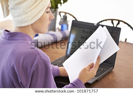 Young lady dressed in purple bath robe reading brief papers