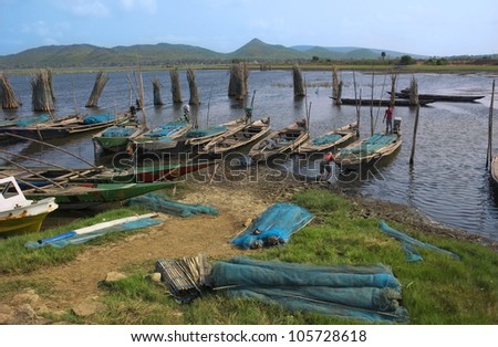 Fishing boats and fishnets of poor Indian fishermen on the shore of a shallow lake