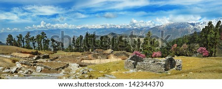 abandoned stone house in the Indian village against the backdrop of high mountain ranges with glaciers