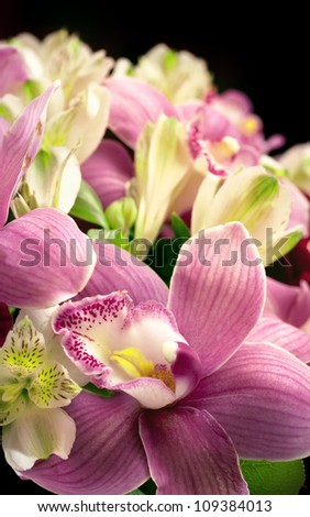 the bouquet from orchids and roses on a black background