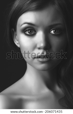 portrait of the beautiful young girl against a dark background. face is close. big eyes