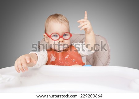 little kid with glasses. mouth milk. finger the top. 
