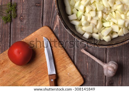 chopped vegetables in a cast iron frying pan on a wooden table. vegetable stew recipe