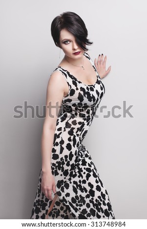 girl posing in white skin-tight leopard dress in studio