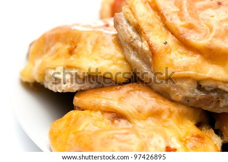 Fried meat stake with onions, tomatoes and cheese on French on a white background. close-up