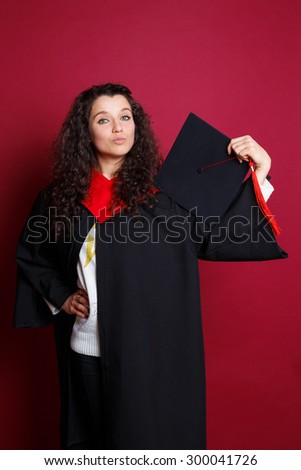 Studio portrait picture from a young graduation woman on red background