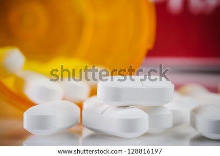 pile of prescription pills with pill bottle in the background